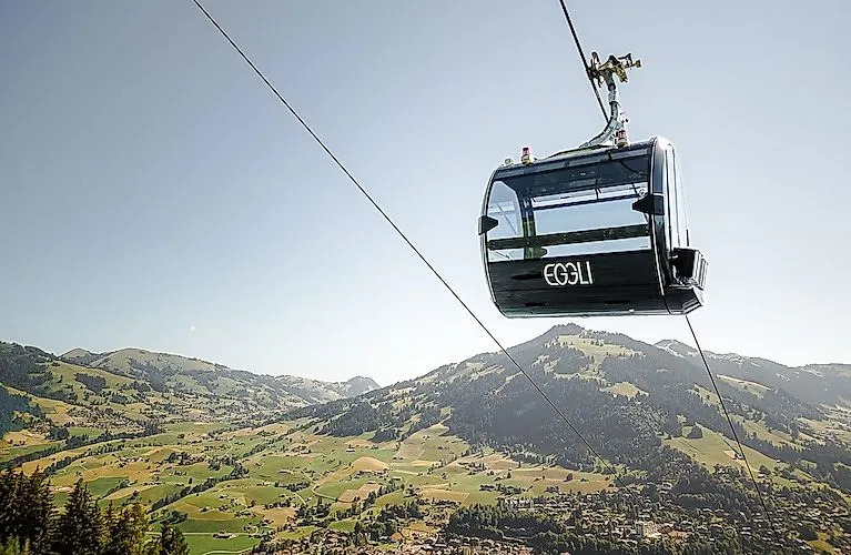 El moderno telecabina Eggli se eleva sobre el veraniego paisaje alpino cerca de Gstaad