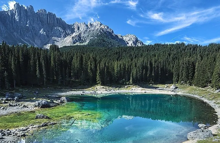Blick auf den Karersee in Carezza mit Spiegelung der Dolomiten im klaren Wasser