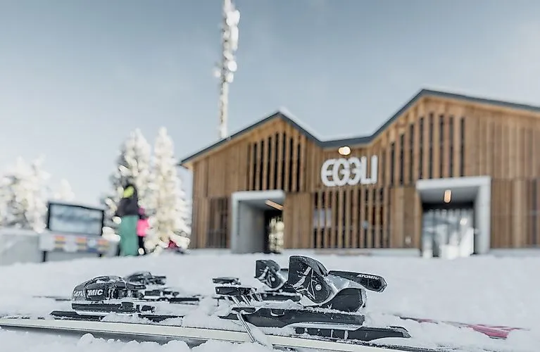 Equipo de esquí frente a la moderna estación de montaña de Eggli, en el paraíso invernal nevado cerca de Gstaad.