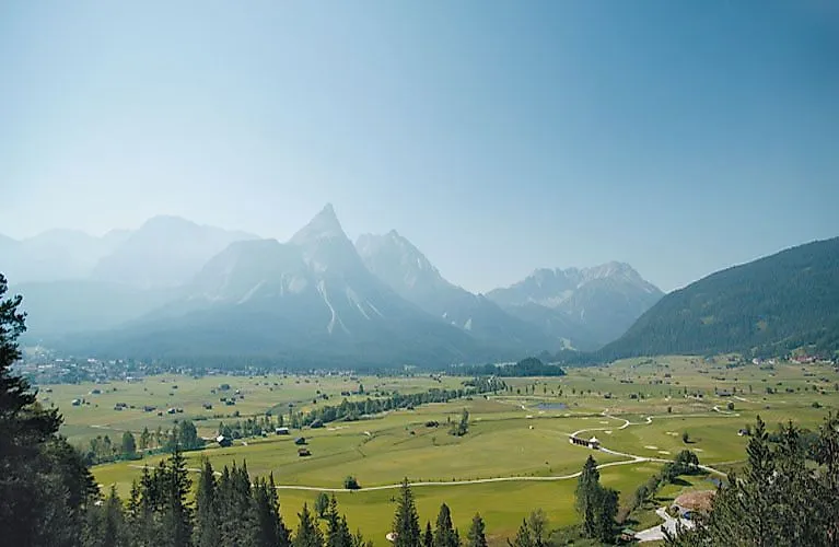 Weitläufiges Tal bei Ehrwald mit Blick auf die markante Zugspitze im Hintergrund an einem klaren Sommertag.