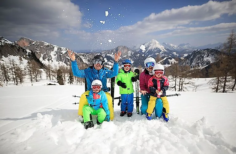 Familie genießt die verschneite Landschaft im Skigebiet Wurzeralm bei Spital am Pyhrn