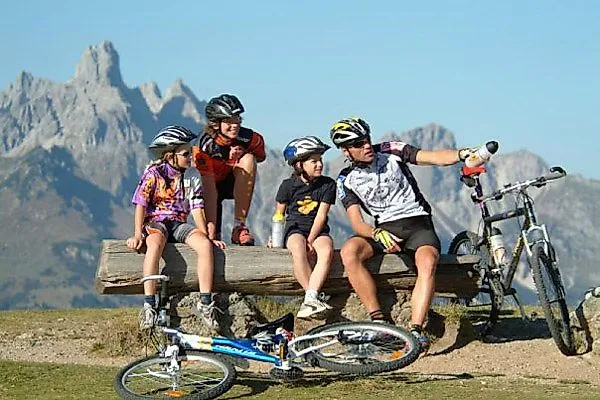 Family mountain biking with a view of the mountains near Radstadt in summer.