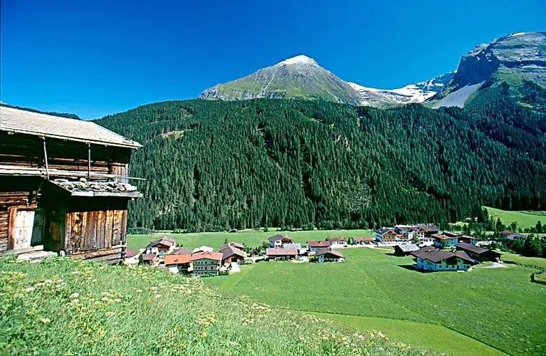 Blick auf das Dorf Finkenberg im grünen Zillertal mit umliegenden Bergen und Wäldern