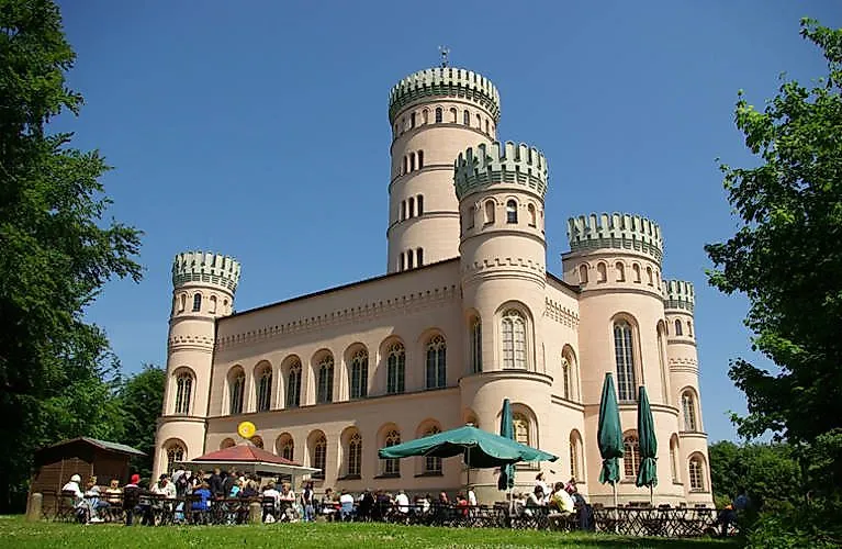 Historický lovecký zámeček Granitz u Binzu na Rujáně s pozoruhodnými kulatými věžemi a venkovním stravováním v letním dni