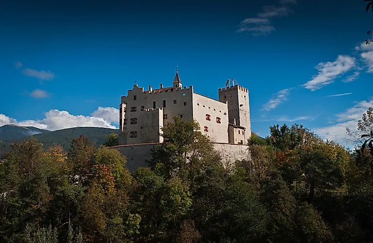 Schloss Bruneck in Südtirol auf einem bewaldeten Hügel oberhalb der Stadt im Pustertal