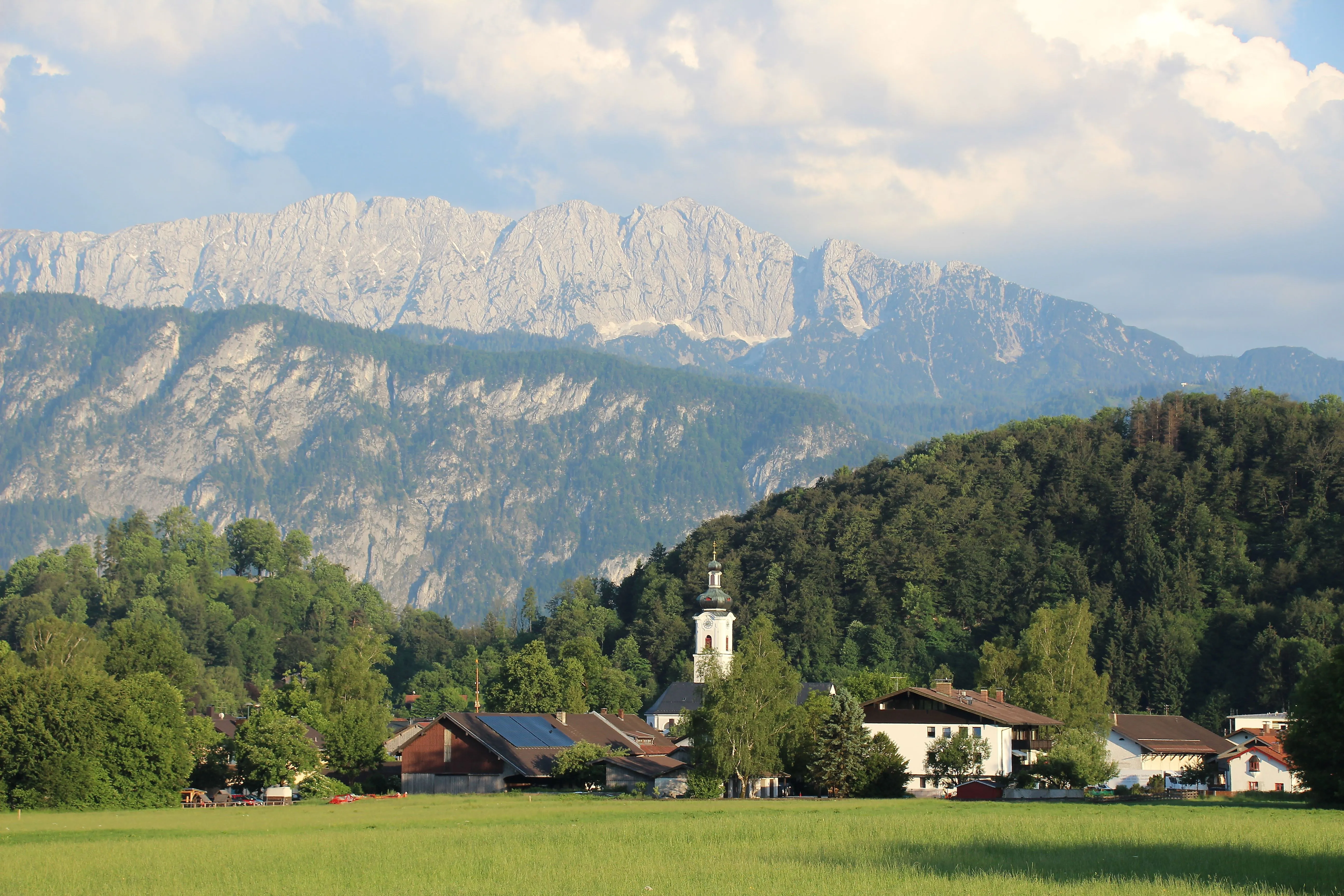 Villaggio di Oberaudorf con chiesa e vista sulle imponenti montagne del Kaiser sullo sfondo