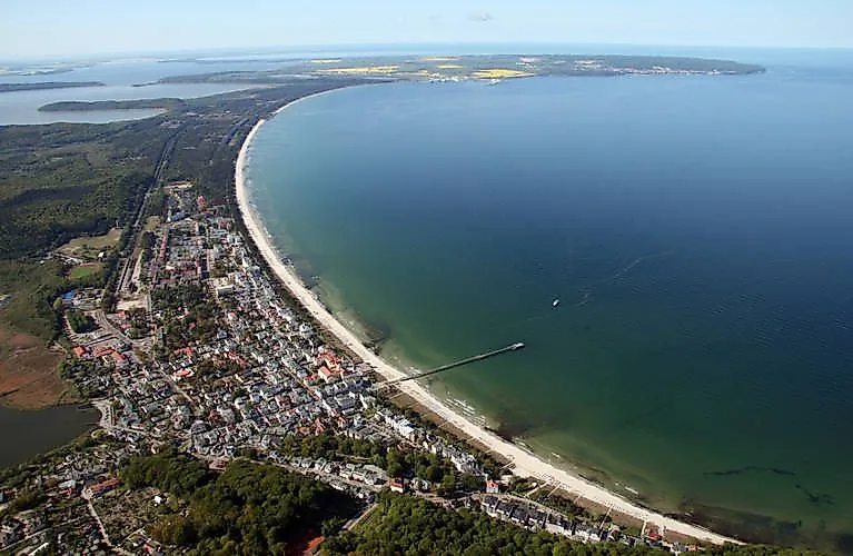 Letecký pohled na přímořské letovisko Binz na Rujáně s dlouhým molem, plážovou promenádou a širokým výhledem na Baltské moře.