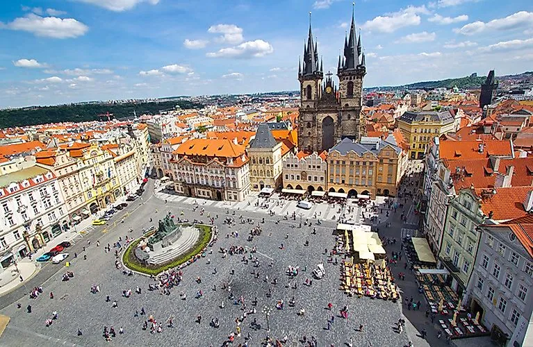 Vista de la Plaza de la Ciudad Vieja de Praga con la Iglesia de Teyn y coloridos edificios históricos bajo el sol