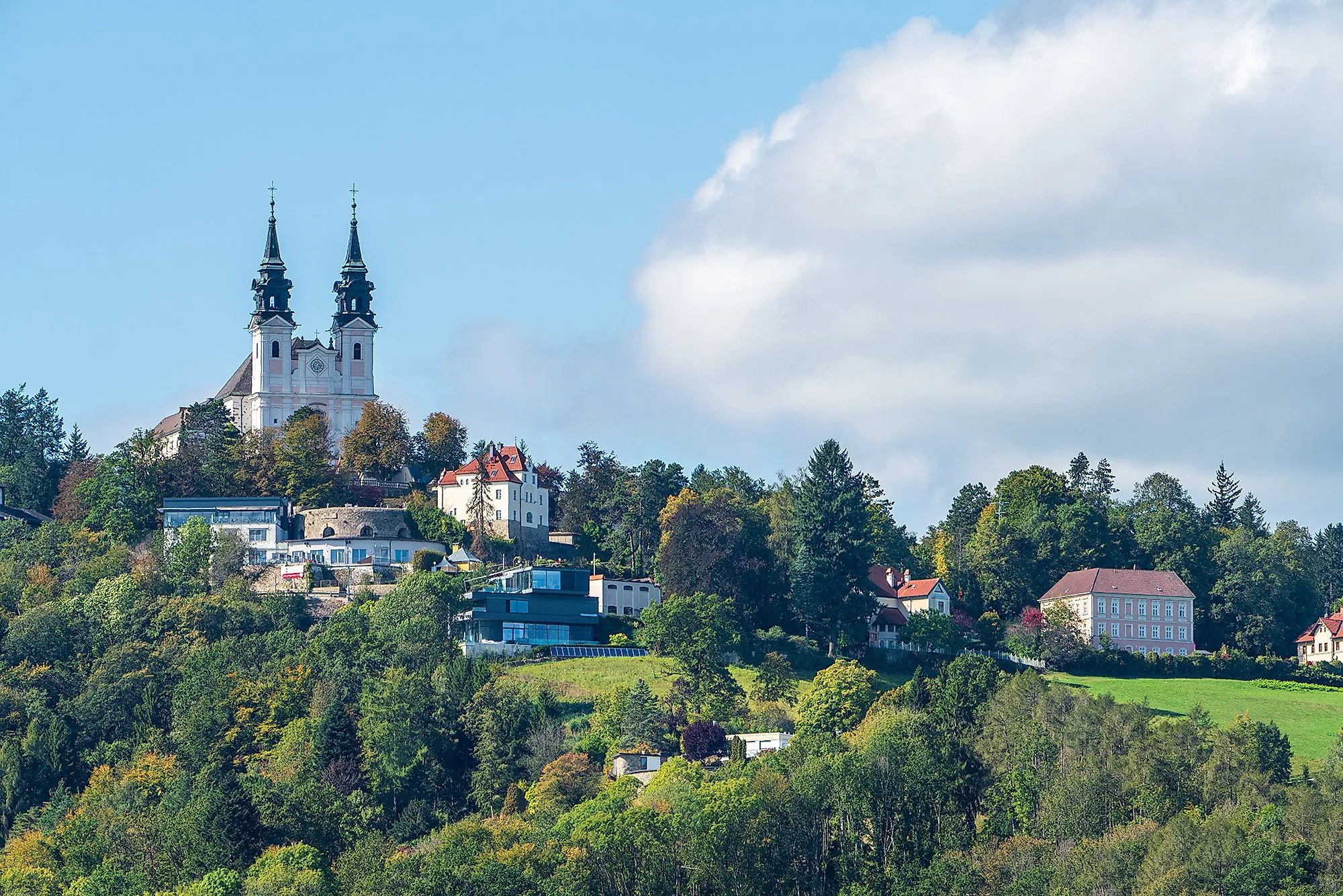 Blick auf den Pöstlingberg mit Wallfahrtsbasilika und grüner Umgebung in Linz