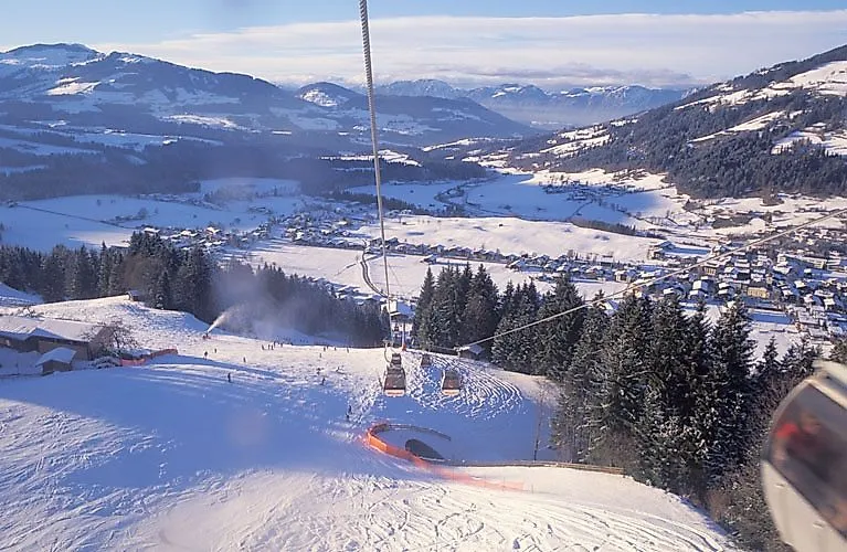 Blick auf Ellmau im Winter mit verschneiten Pisten und Gondelbahn in der SkiWelt Wilder Kaiser.
