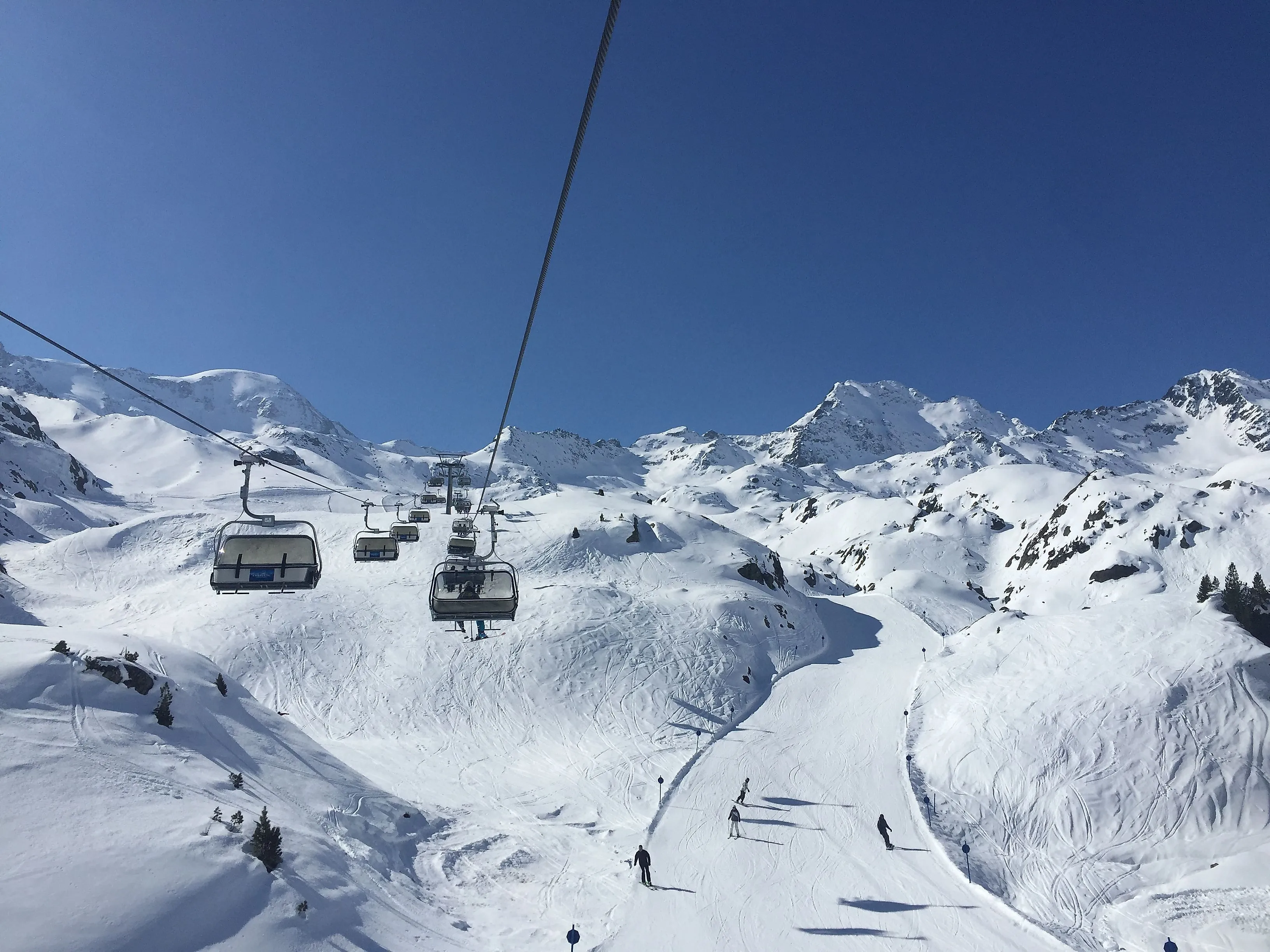 Sessellift über schneebedeckte Piste mit Wintersportlern im Skigebiet Kaunertal.