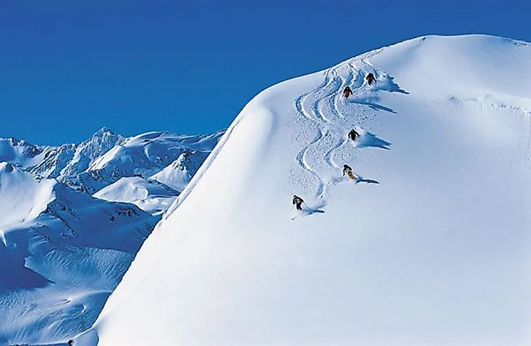 Esquiadores esquiando en nieve profunda en St. Anton am Arlberg bajo el sol