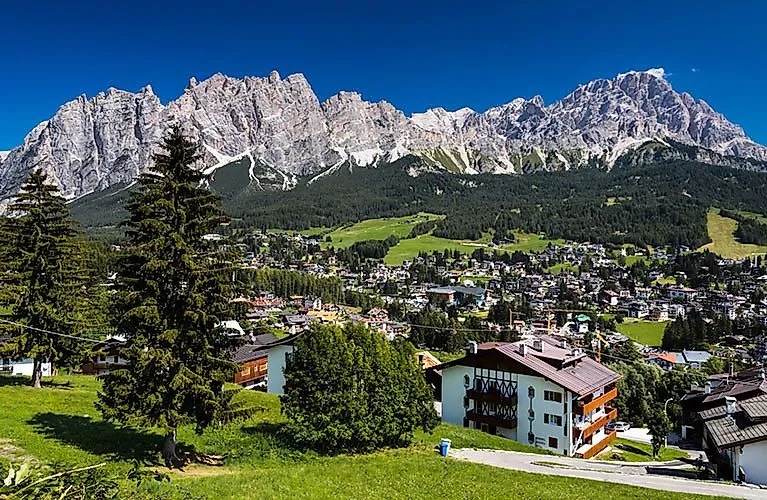 Panoramablick auf Cortina d’Ampezzo mit traditionellen Häusern und markanter Dolomiten-Bergkette