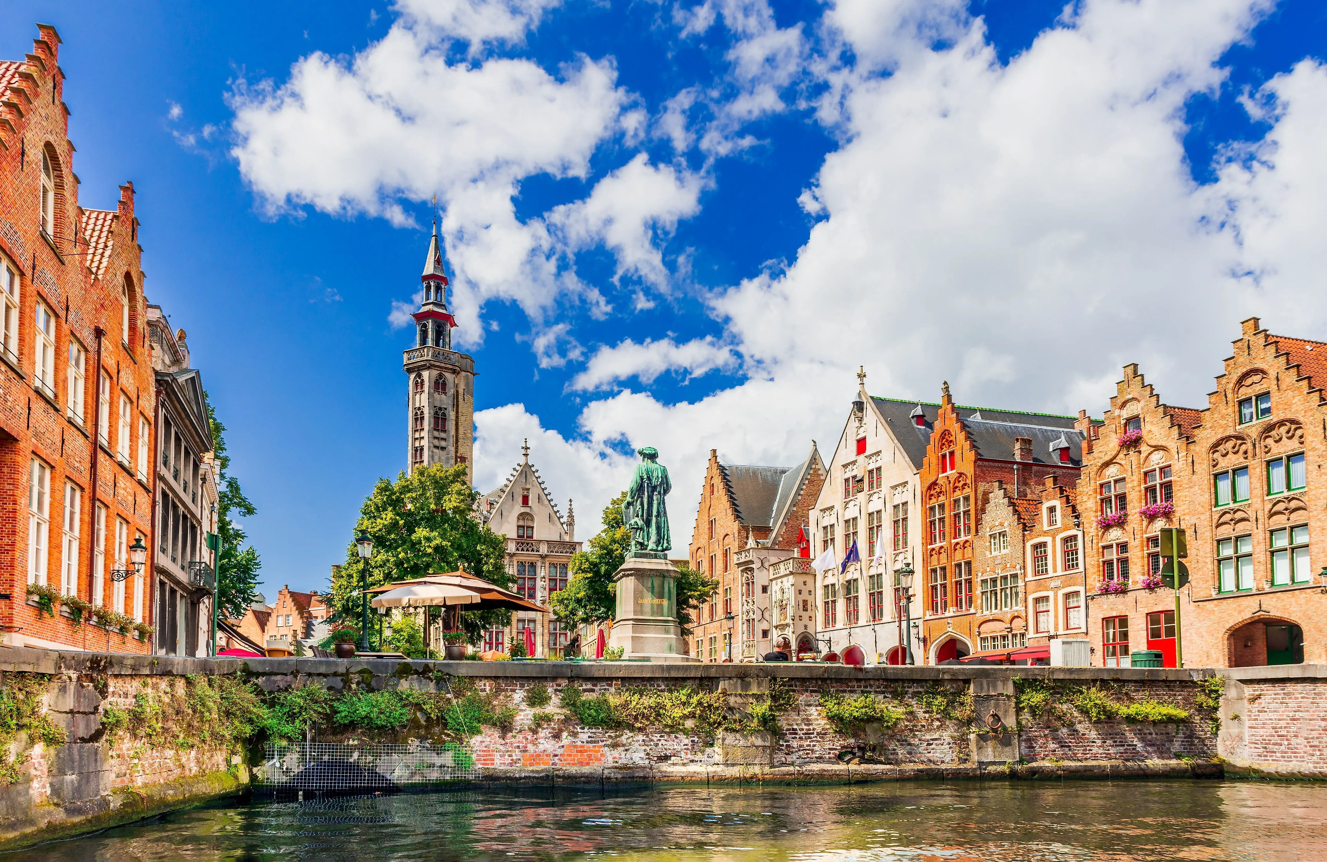 Gracht in Brügge mit historischen Giebelhäusern und Jan-Breydel-Statue bei Sonnenschein
