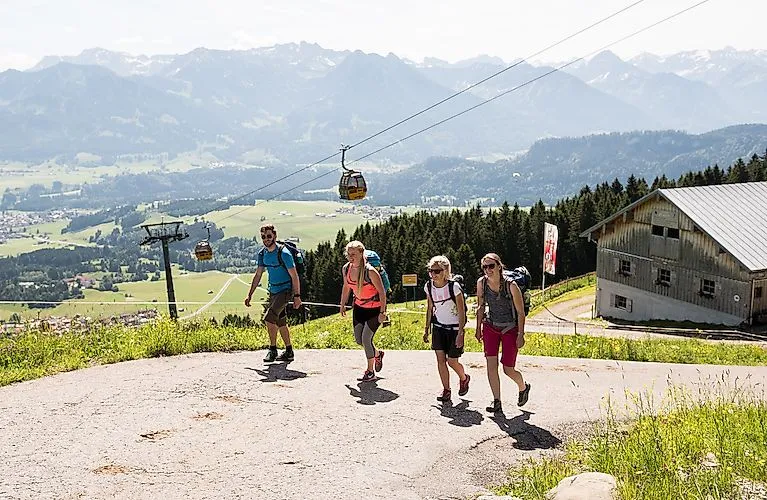 Wanderer bei der Hörnerbahn in Bolsterlang – sonniger Tag mit Blick über das Tal und die Allgäuer Alpen