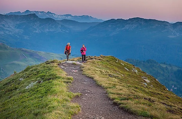 Zwei Wanderer auf dem Schoberriegel in der Morgendämmerung auf der Turracher Höhe