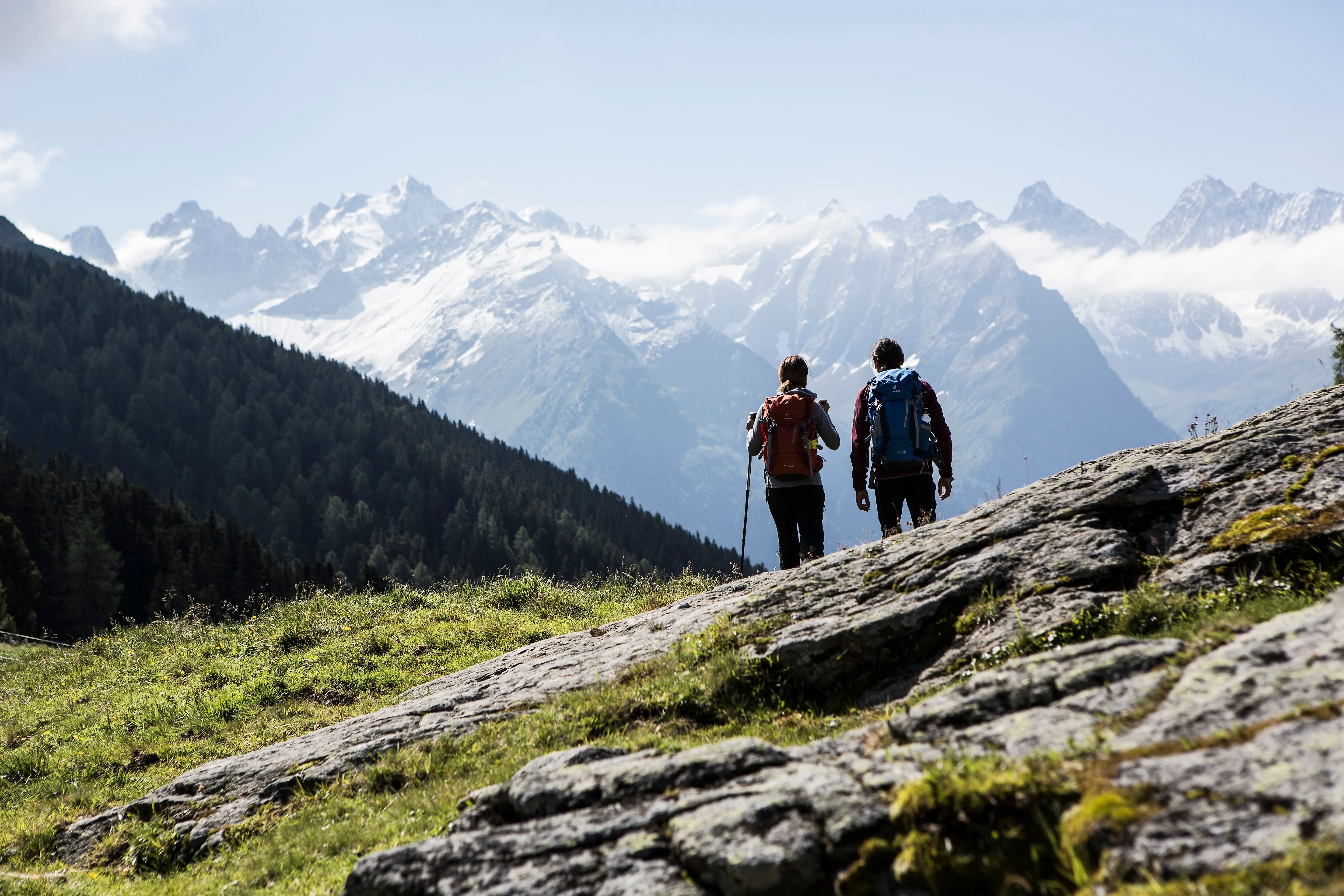 Zwei Wanderer auf Almwiese mit Blick auf verschneite Berggipfel im Kaunertal.