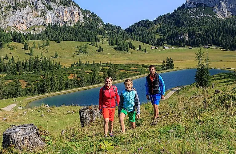Familie wandert im Sommer entlang eines Bergsees bei Spital am Pyhrn in Oberösterreich