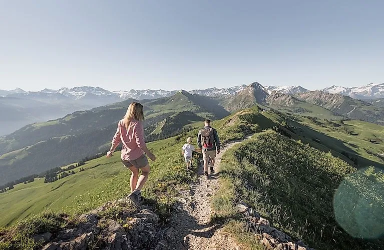 Wandelen met het gezin over een bergpad met een prachtig uitzicht op het groene Alpenpanorama rond Zweisimmen.