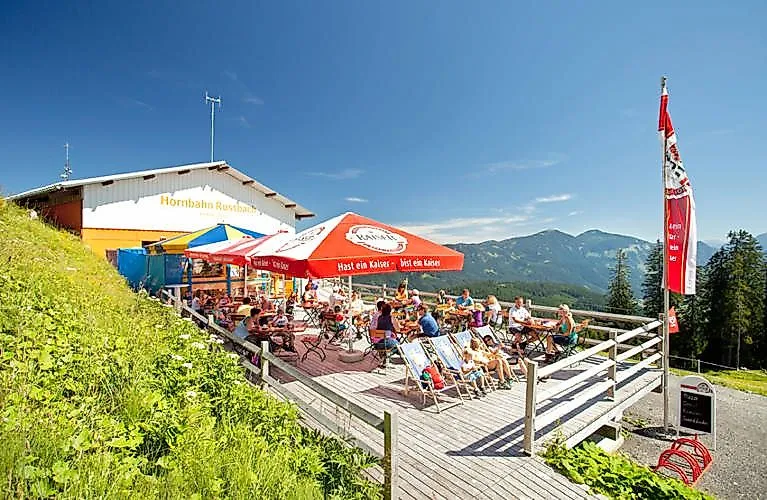 Ospiti sulla terrazza solarium della funivia Hornbahn Russbach con vista sulle montagne di Salisburgo