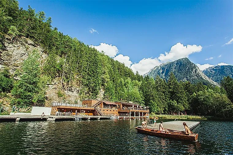 Kinder beim Bootfahren vor dem Badehaus am Piburger See an einem sonnigen Sommertag